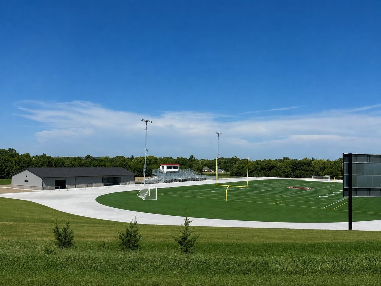 Sports complex with a new metal building, concrete walks and turf field, a project by Elevated Masonry & Exteriors in Nebraska