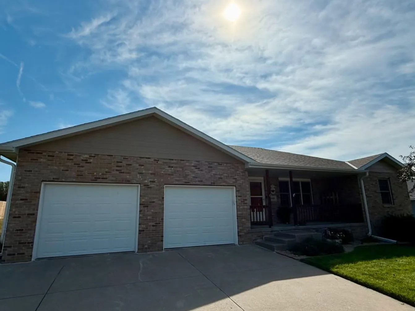 Brick ranch house with a shingle roof and a two door garage